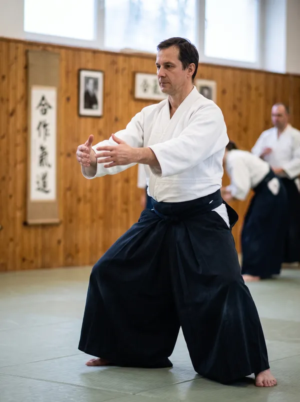 Hakamás aikidós csikung-tartásban a dojo tatamiján